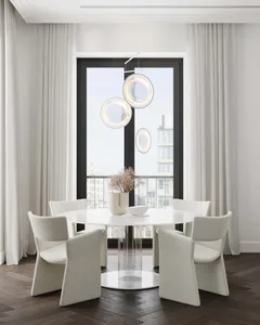 Modern dining room featuring fabric chairs, a glass table, and wooden flooring.