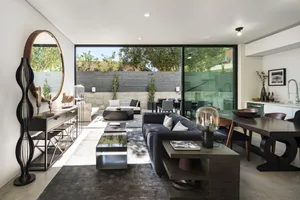 Modern living room featuring a concrete fireplace, black furniture, and a sleek design.