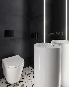 Modern minimalist bathroom with black ceramic tiles and a white freestanding sink with a terrazzo floor.