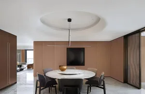 Modern minimalist dining room with a marble table and wood walls.