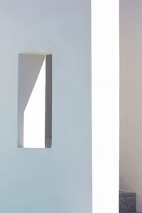 A minimalist white concrete architectural detail with a rectangular cutout.