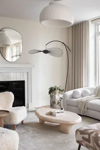 A modern living room featuring marble furniture and upholstered fabric seating.