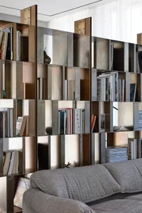 Modern living room featuring a metal sculpture shelf displaying books and decorative items.