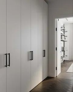 Close-up of a modern, minimalist white cabinet with sleek, black handles.