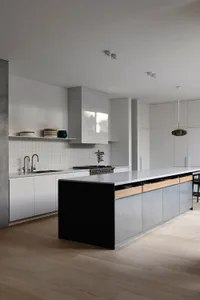 Modern minimalist kitchen with concrete flooring, stainless steel appliances, and white marble countertops.