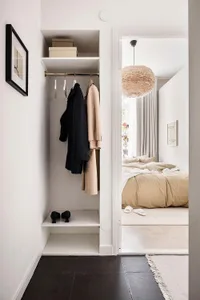 A minimalist bedroom featuring neutral tones with a cozy bed and simple decor.