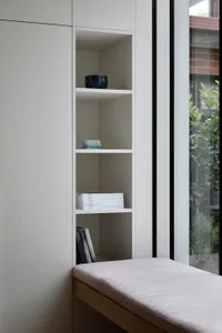Minimalist interior design featuring a sleek granite bookshelf with neatly organized books and decorative items.
