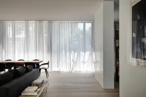 A modern living space featuring transparent curtains.