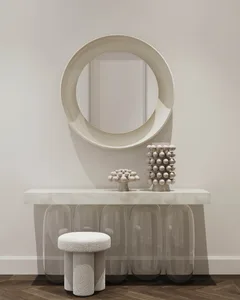 A modern entryway featuring concrete and glass materials, with a circular mirror and decorative objects on a sleek console ta
