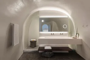 A modern bathroom featuring white stone surfaces and minimalistic design.