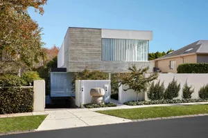 A modern house with a contemporary design featuring concrete, glass, and wood exteriors.