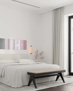 A modern minimalist bedroom featuring a fabric bed and wooden bench.