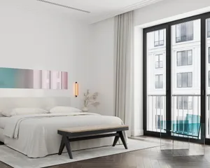 A modern bedroom with a neutral-toned color palette and a large window.