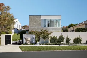 A modern residential building featuring a concrete and glass exterior.