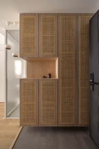 Modern interior entryway featuring a combination of wood and cane material for storage