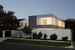 A modern house with a concrete exterior during twilight.