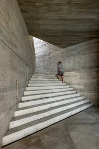 A modern, industrial-styled staircase constructed from concrete, featuring a minimalist design with smooth, clean lines.