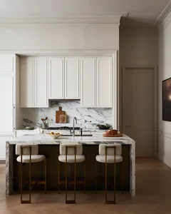 Modern kitchen featuring a marble countertop and white cabinets.