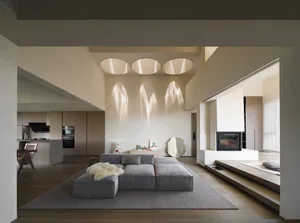 A modern living room with a neutral color palette featuring a sectional sofa, area rug, and minimalist decor.