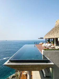 Modern vacation home with a glass infinity pool overlooking the sea.