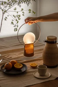 A hand adjusting a modern table lamp made of metal and plastic blend.,
