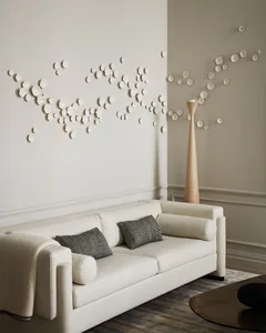 A modern living room featuring a white couch adorned with cushions and a blanket, accompanied by a decorative rug and glass c
