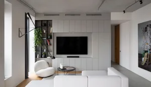 A modern living room with white furniture and concrete walls.
