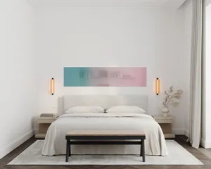 A minimalist bedroom with a textured fabric headboard, bedside tables, and a cozy white bedspread.