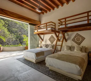 A minimalist bedroom featuring wooden furnishings and a natural outdoor view.
