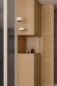 Modern interior design featuring a wooden storage cabinet with built-in lighting and a decorative shelf.