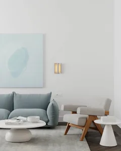 Contemporary minimalist living room featuring a modern sofa in soft pastel blue, a wooden armchair, and a round coffee table 