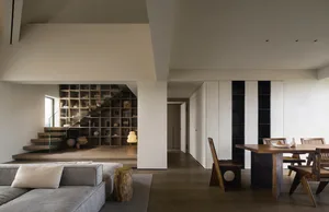 A modern interior design featuring wooden furniture, concrete walls, and glass elements.