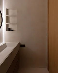 Minimalist bathroom with concrete walls and floating vanity.