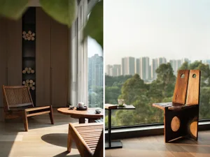 Modern wooden living room featuring slatted wooden chairs and a round table with a tea service, set against a backdrop of cit