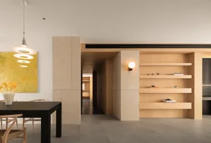 現代簡約餐廳，鋪設混凝土地板、木質層架，以及黑色餐桌。