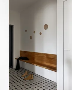 Entryway featuring a minimalist design with a wooden bench and ceramic tiles