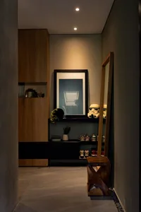 A minimalist entryway featuring a wooden shoe rack with shoes and a decorative star wars helmet.