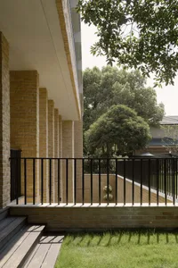 Modern residential building with brick facade and garden view.