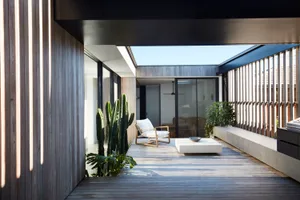 Modern residential extension featuring wooden decks and extensive glazing.
