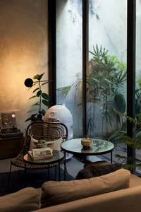 A cozy modern-industrial living room featuring wooden furniture, a round glass coffee table, and a cozy sofa.