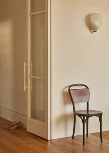 Modern minimalist chair made of wood with leather seating and backrest, set against a minimalist interior design with hardwoo