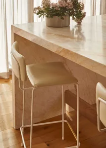 Modern kitchen with marble countertop and stool.