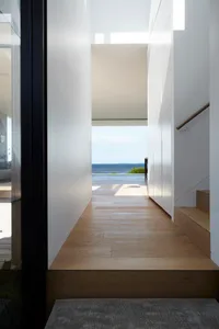 Modern residential entryway featuring wooden flooring and a view of the ocean.