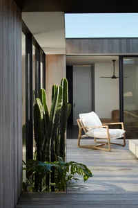 Modern residential space featuring wooden elements, white furniture, and green plants.