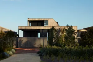 Modern residential home with wooden exterior on a clear day.