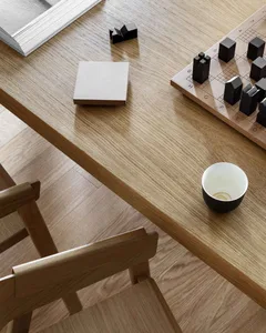 Wooden interior with a tutorial book, coffee cup, and chessboard.