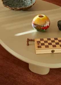 A wooden chessboard and vase on a coffee table.