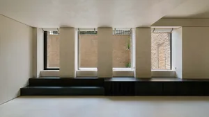 A minimalist interior design featuring concrete elements in a living room setting.
