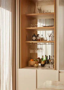 A modern bar station with wooden shelves containing various bottles and glasses.