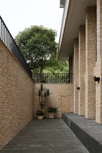 Modern outdoor patio with brick walls and a tree